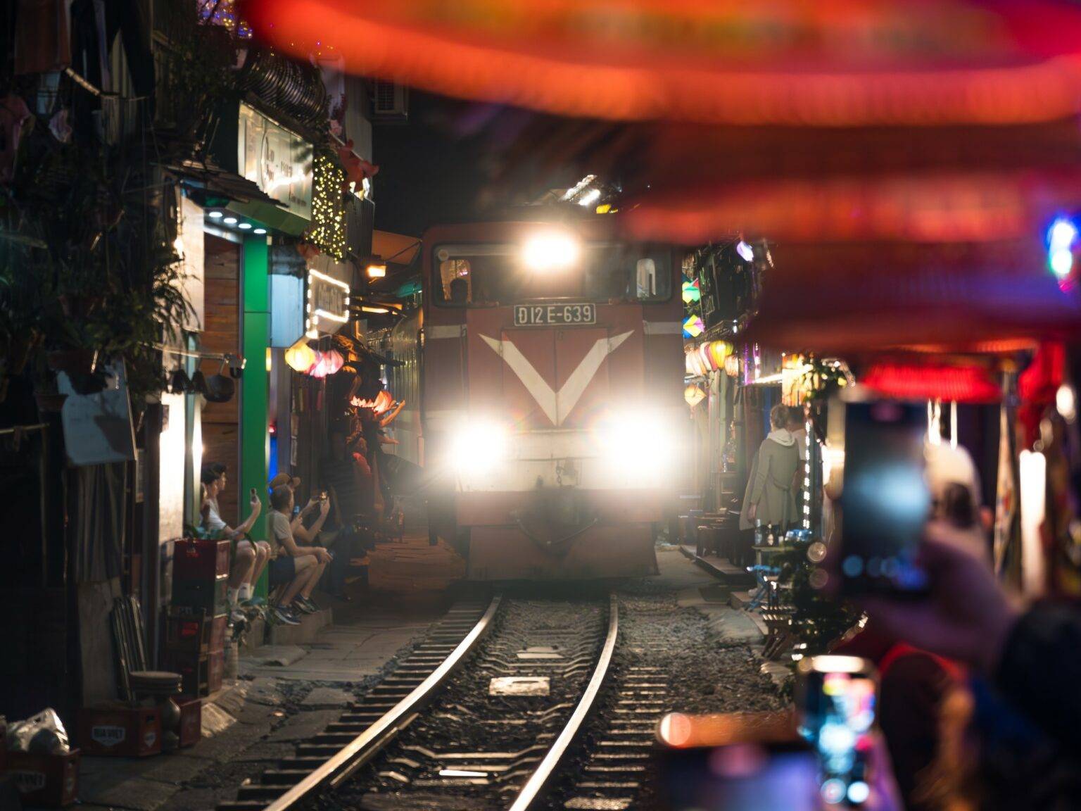 Ein Zug fährt am Abend durch die Train Street in Hanoi.