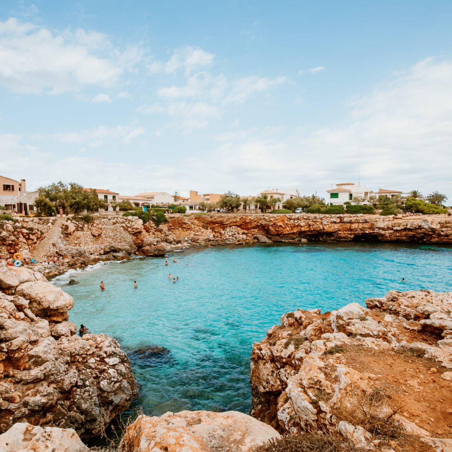 In der Bucht Cala Morlanda umfassen felsige Vorsprünge das türkisblaue Meer.