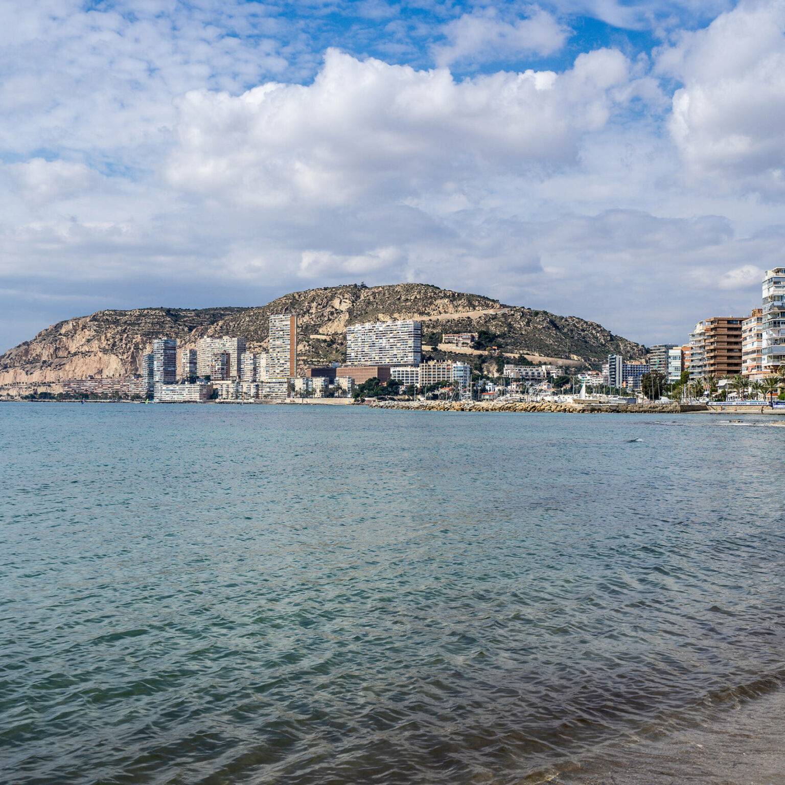 Blaues Meer im Vordergrund der Playa de la Almadraba auf Alicante.