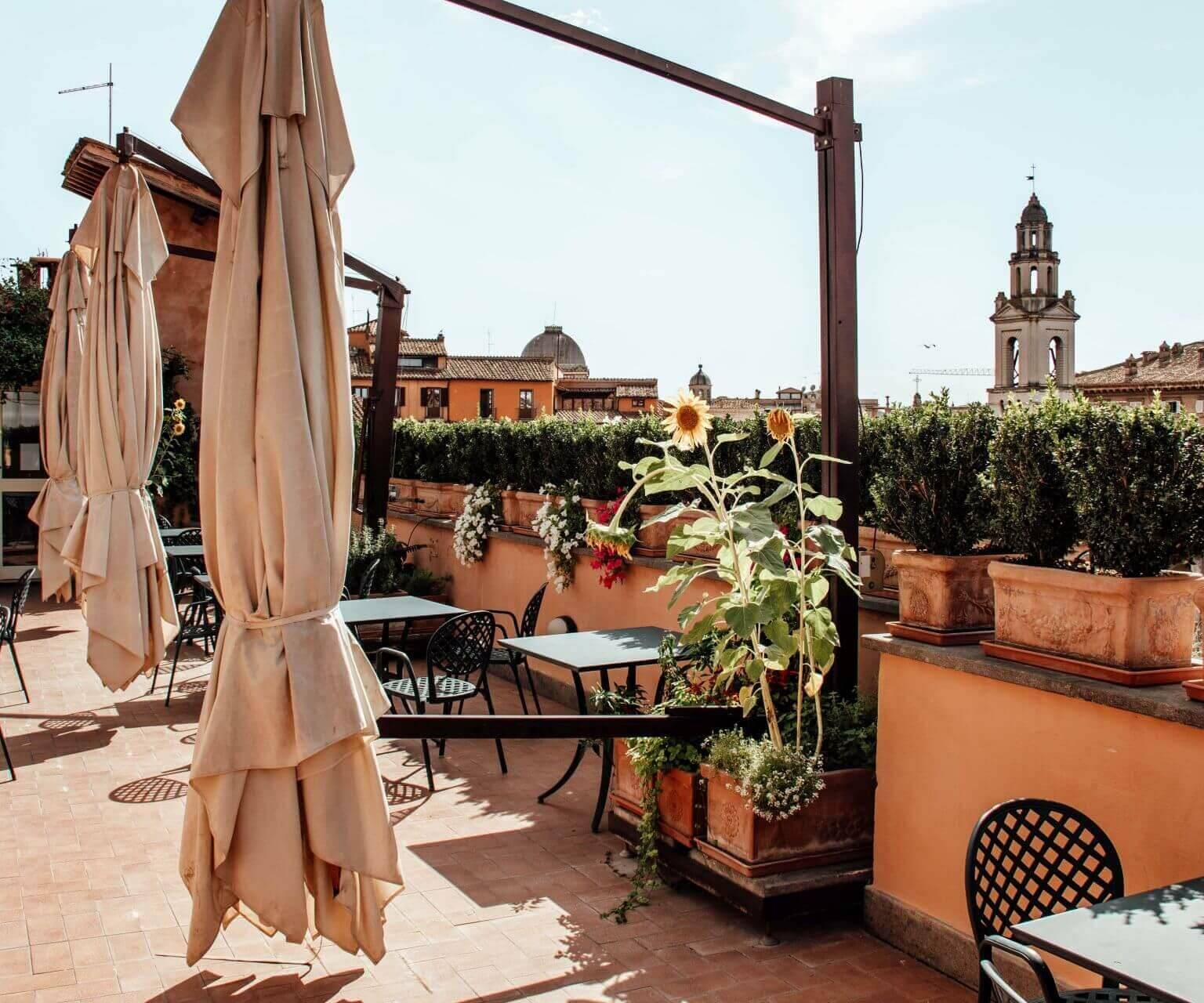 Die Terrasse des Hotel Hosianum Palace in Rom bestückt mit Stühlen und Schirmen.