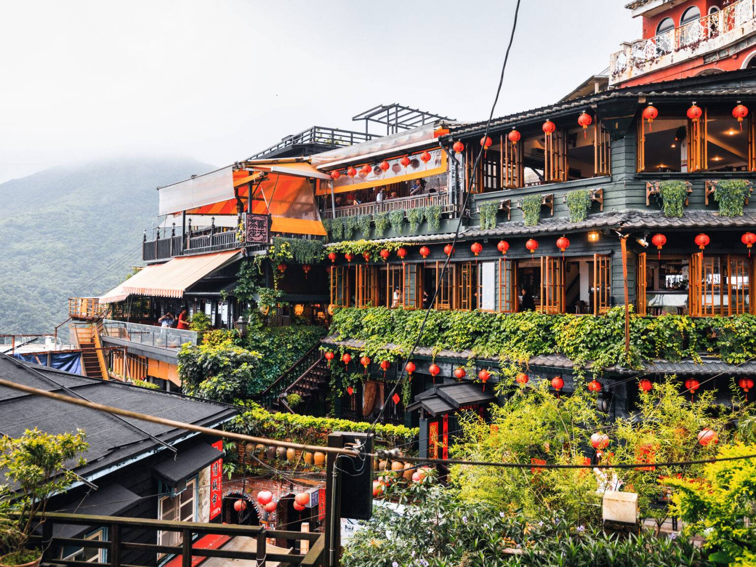 Die Häuser im Bergdorf Jiufen in Taiwan sind geschmückt mit orangenen Lampions.