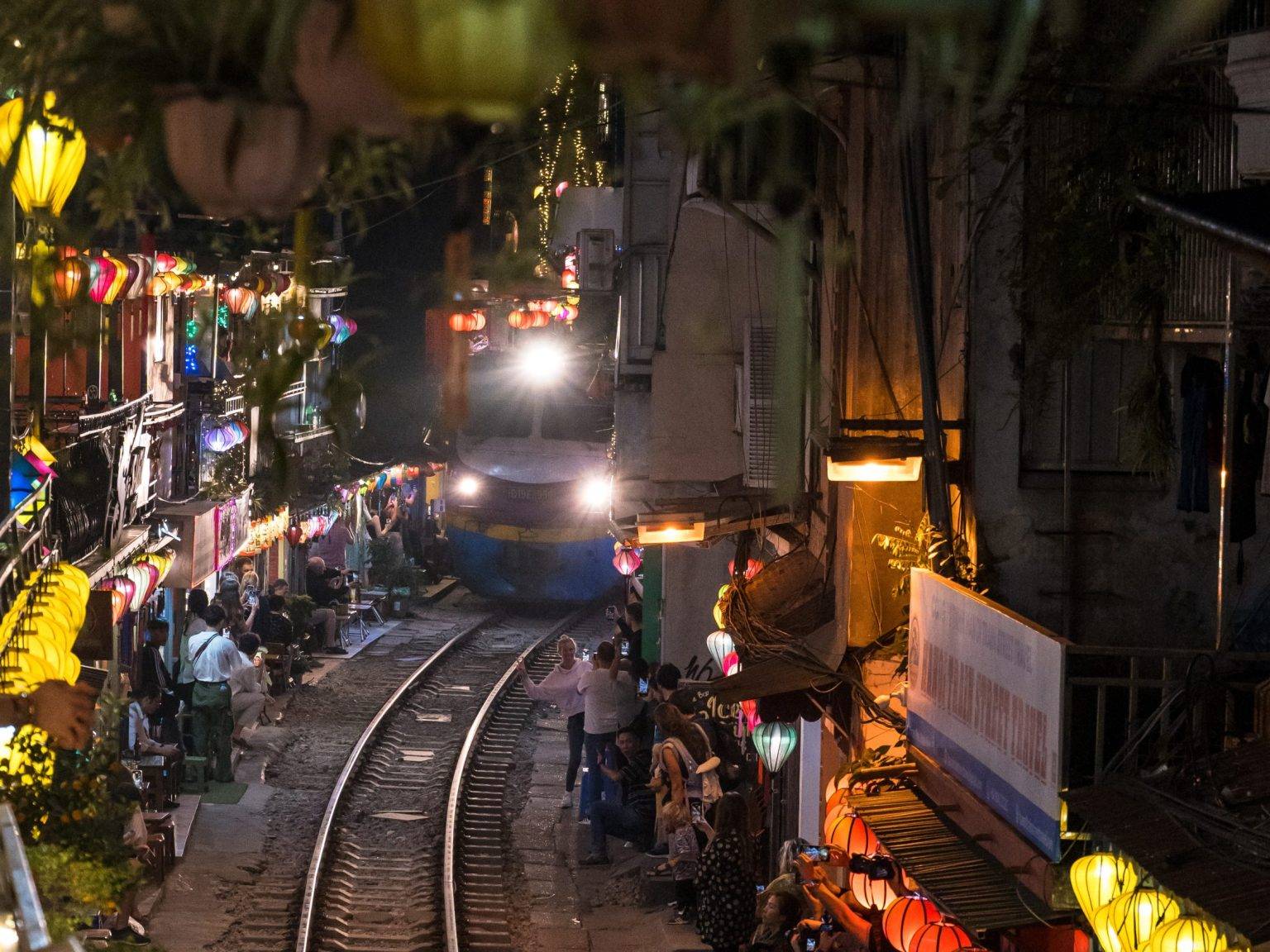 Ein Zug fährt bei Nacht durch die Train Street in Hanoi.