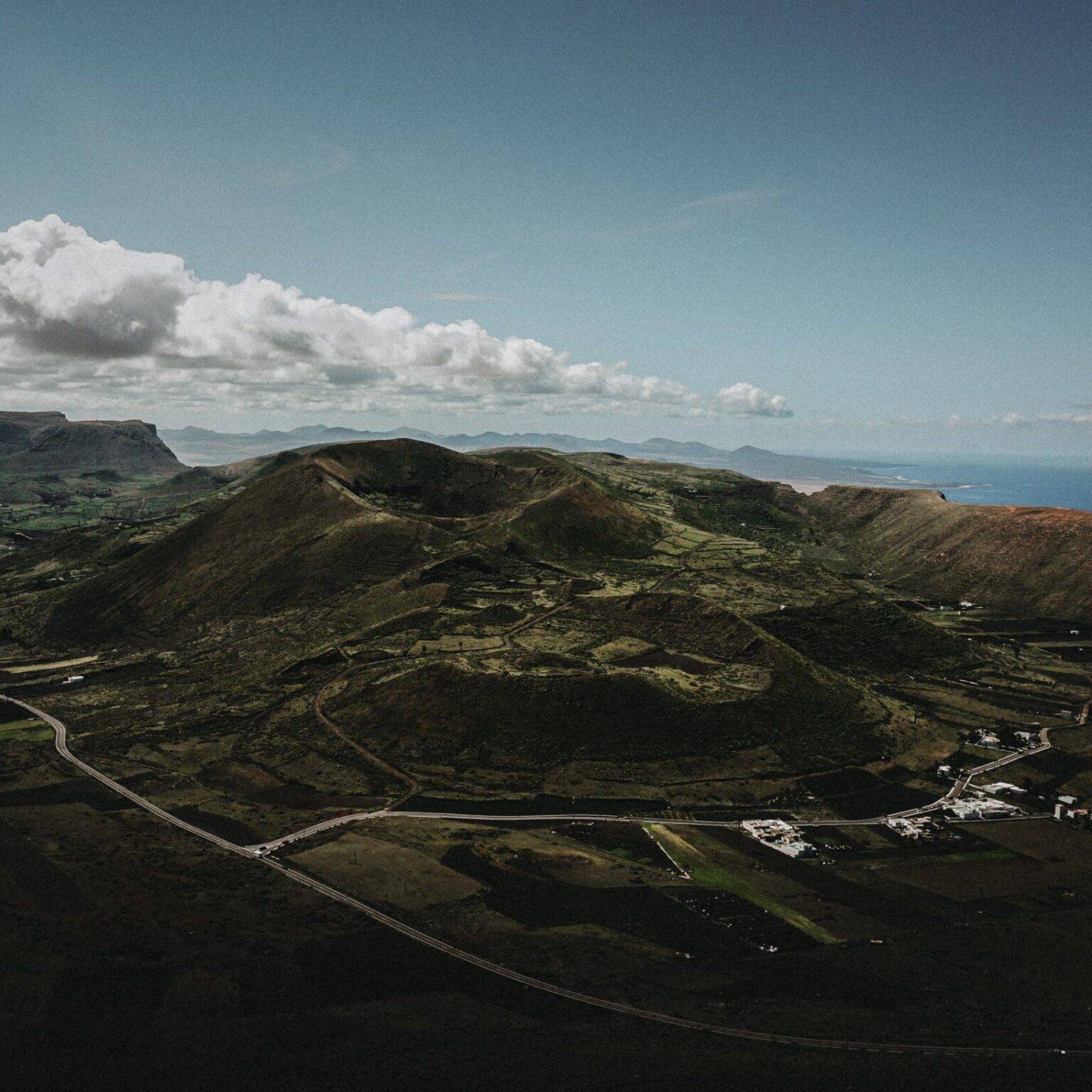 Blick aus der Vogelperspektive über die weiten grünen Berge Lanzarotes.