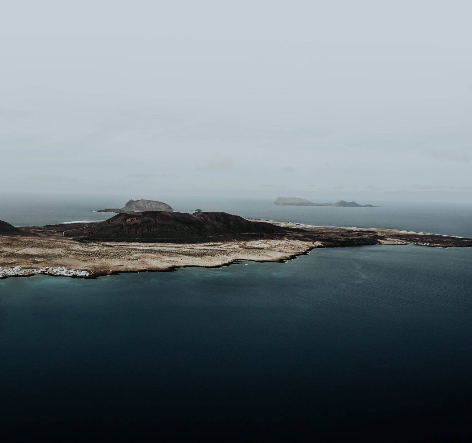 Blick über die Insel Lanzarote, im Hintergrund weitere kleinere Inseln und das Meer.