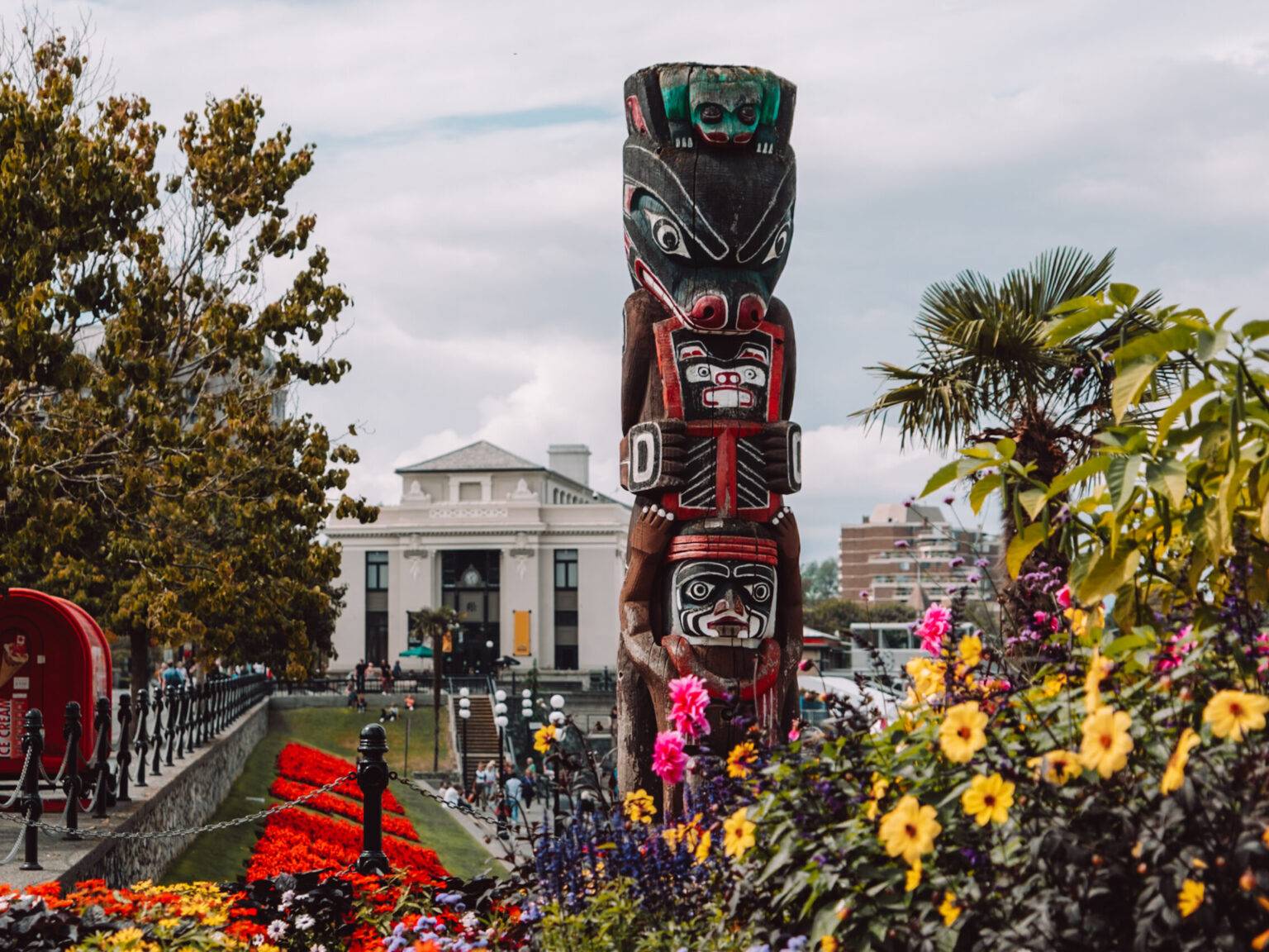 Ein Totempfahl der Kwakiutl umgeben von Blumen.