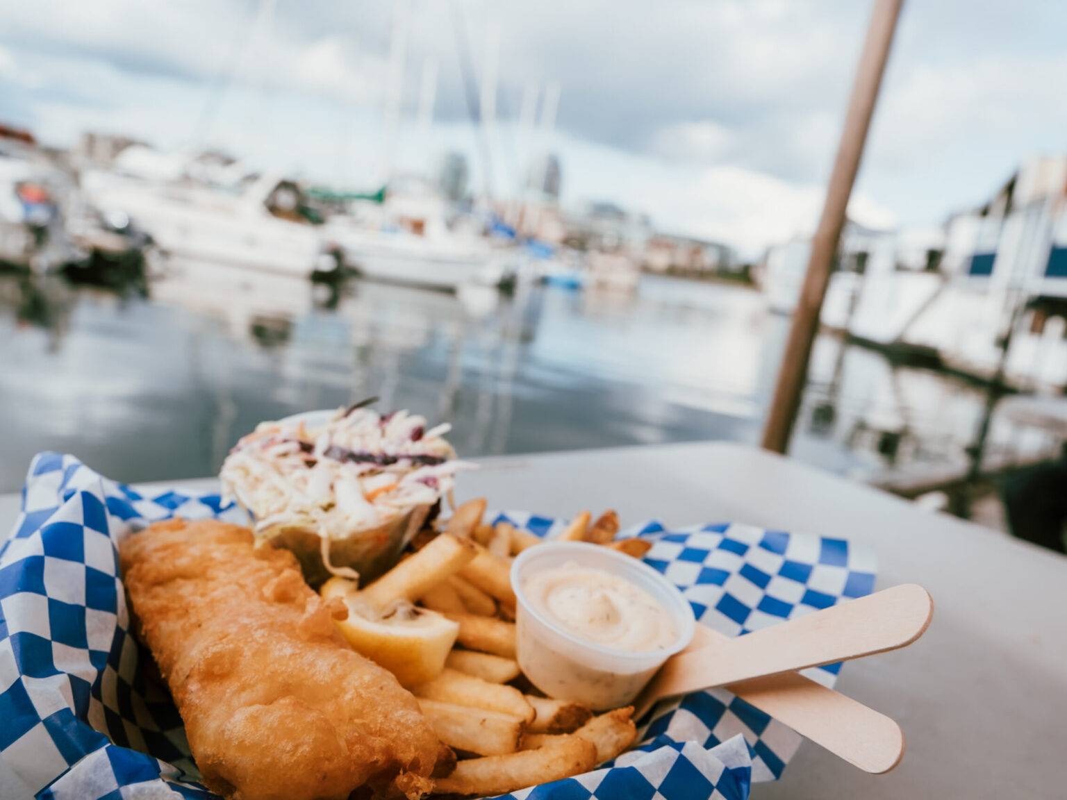 Eine Portion Fish & Chips und der Hafen im Hintergrund.