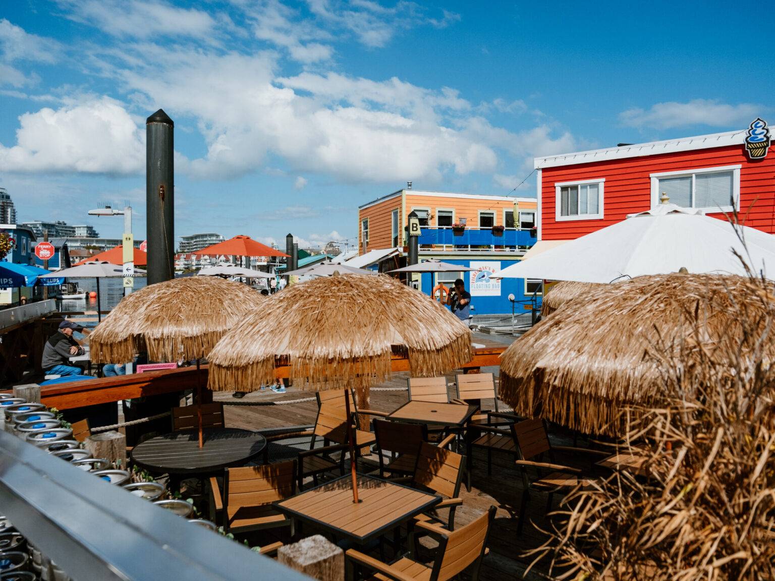 Sitzgruppen mit Sonnenschirmen und bunte Häuschen in der Fisherman’s Wharf.