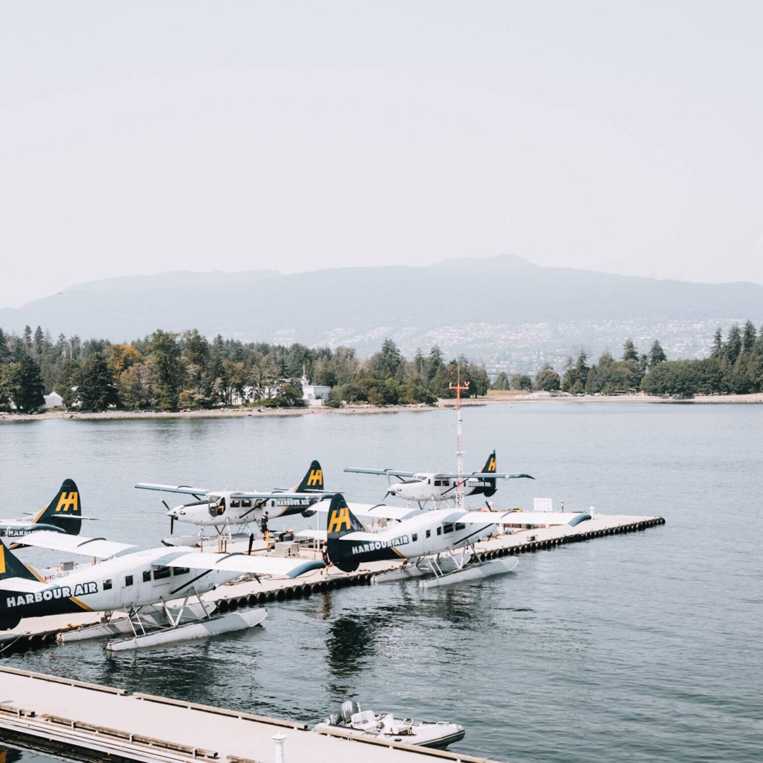 Einiger Wasserflugzeuge parken an einem Steg im Wasser.