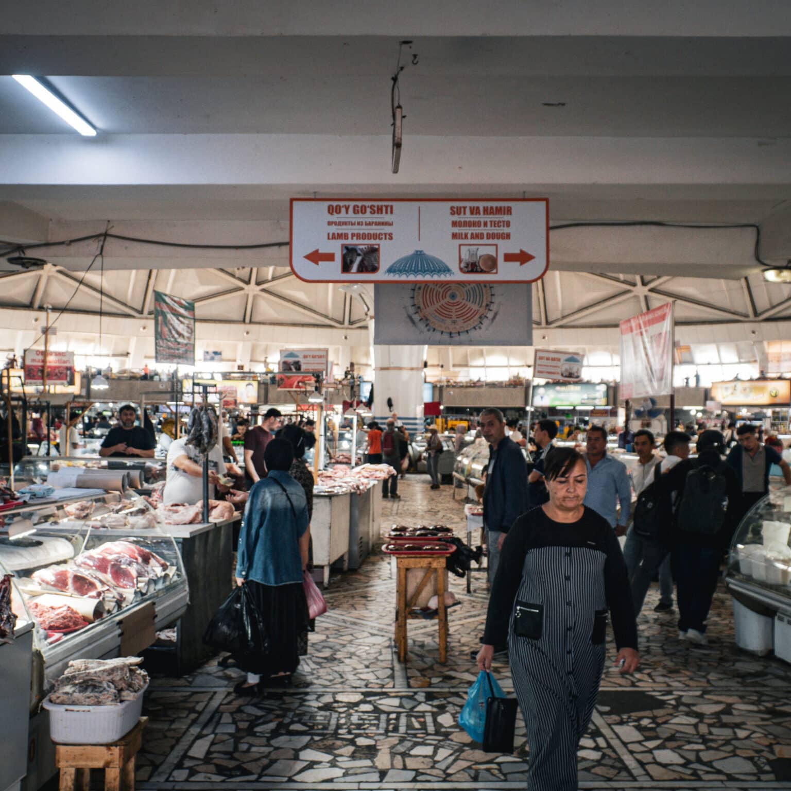 Innenansicht der Markthalle des Chorsu-Basars in Taschkent mit Ständen für Fleisch- und Milchprodukte