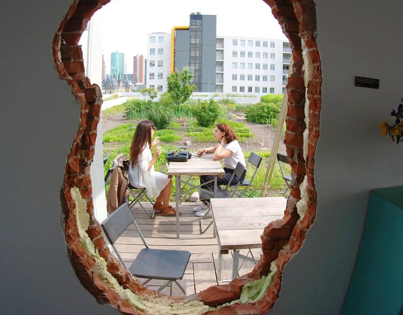 Durch ein Loch in der Wand können Gäste im Rotterdamer Dachterrassencafé Op het Dak von innen auf den Garten des Lokals schauen.