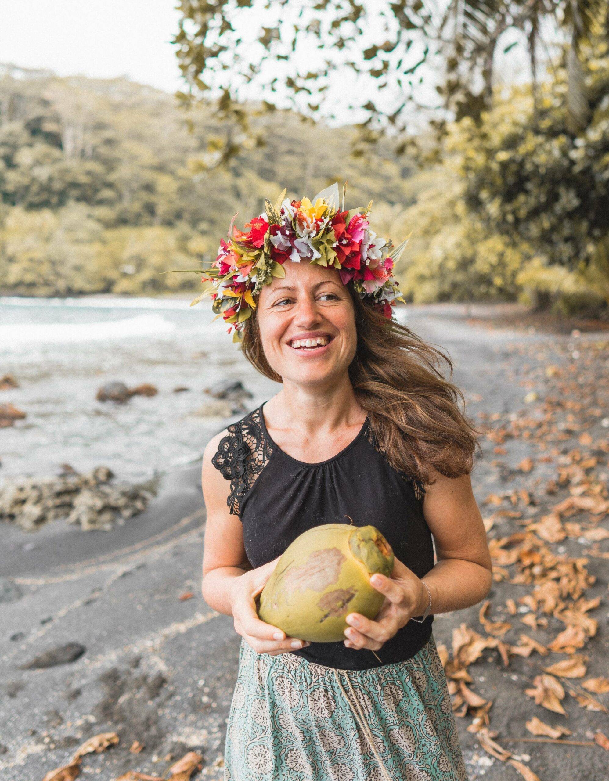 Reisebloggerin Melanie Schillinger vom Blog Good morning world mit einer Kokosnuss in der Hand und Blumenkranz auf dem Kopf.