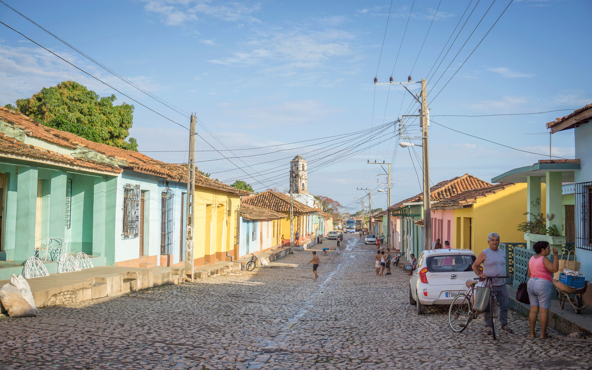 Bunte Häuser säumen die gepflasterte Straße auf der Kinder spielen in Kuba, Trinidad.