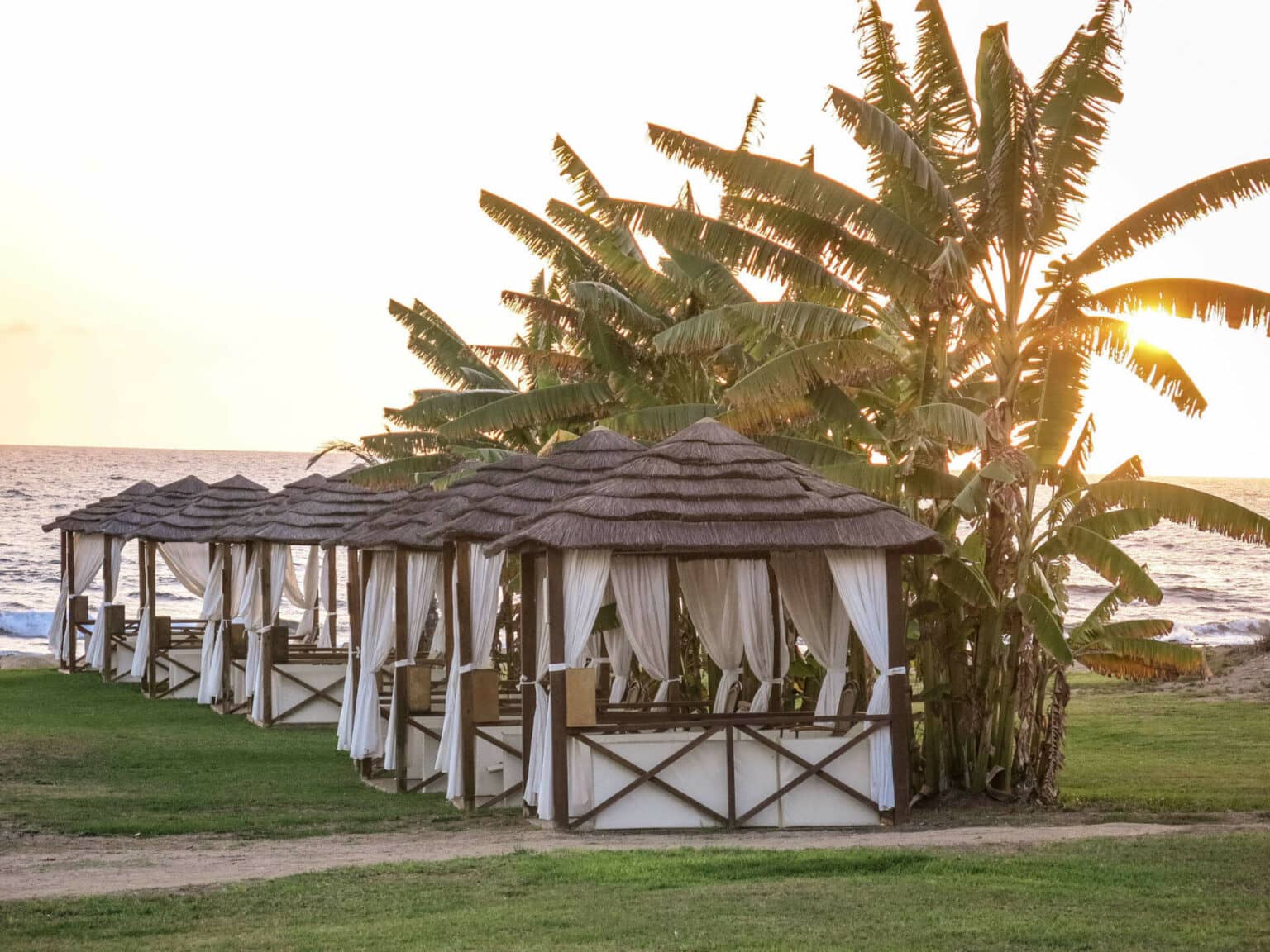 Kleine Strändhäuser in Paphos auf Zypern reihen sich an der Strandpromenade aneinander.