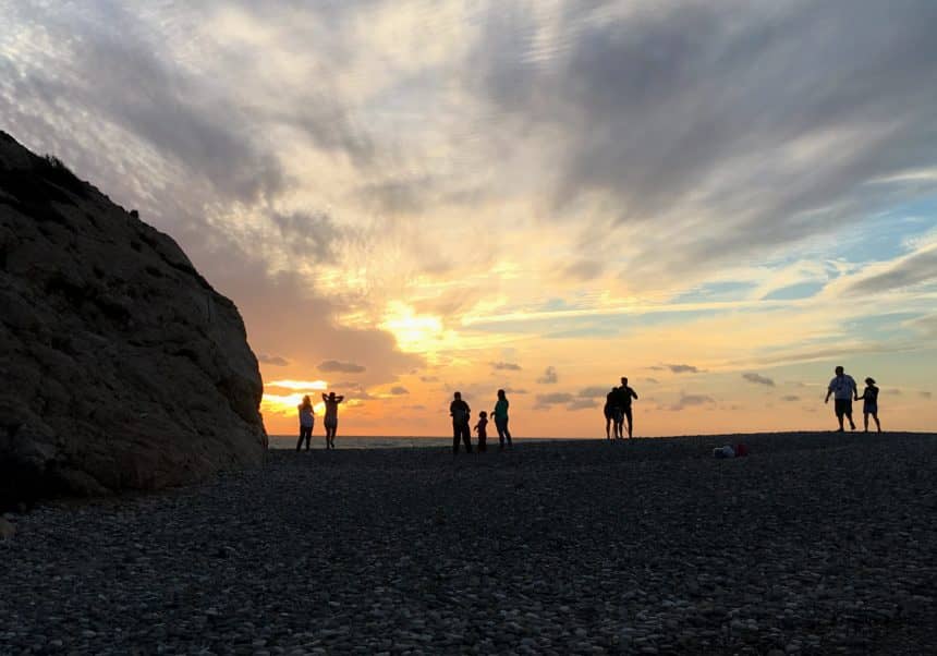 Der Sonnenuntergang taucht den Strand von Petra tou Romiou auf Zypern in goldenes Licht.