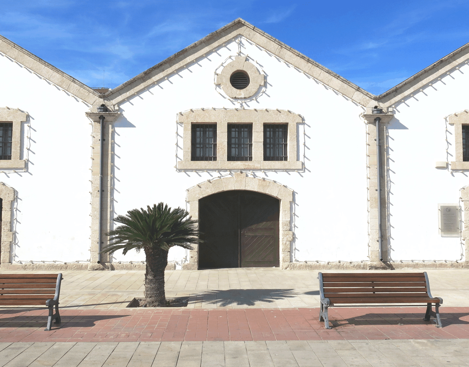 Die Häuschen des Kulturzentrums in Larnaka, Zypern sind im Kolonialstil in weiß gehalten, die in Steinen gefassten Fenster und Tore sind mit Lichterketten eingerahmt.