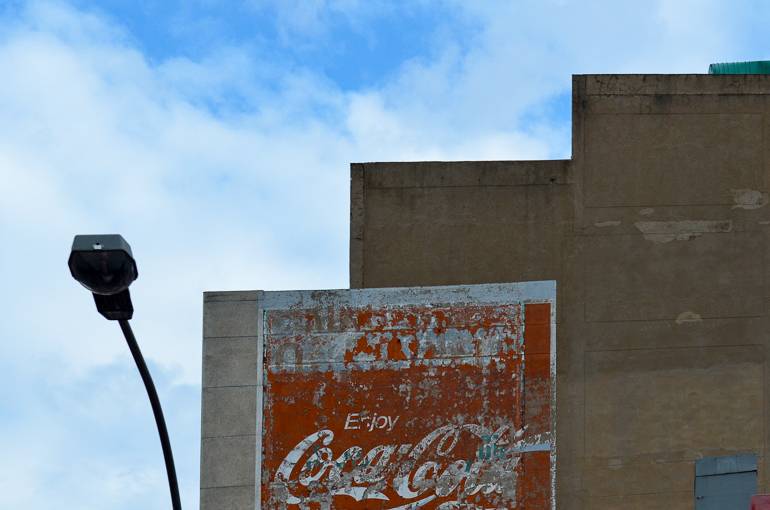 Auf einer Hauswand in Johannesburg Brammfontein hängt ein altes Coca-Cola-Werbeschild.