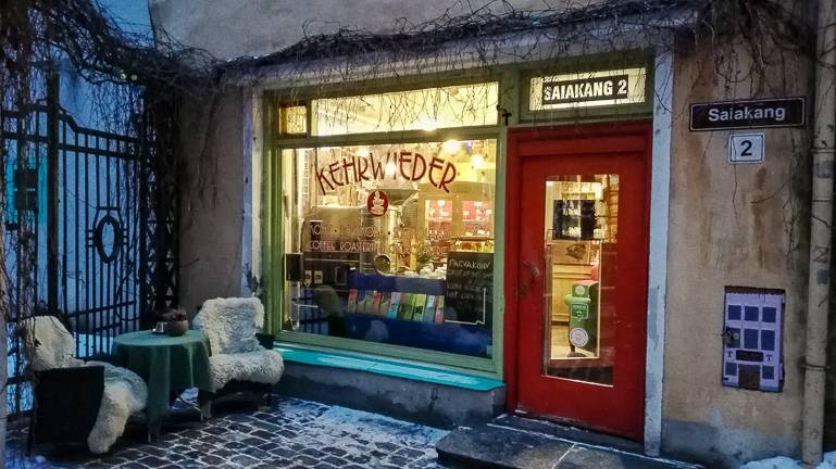 Das Schaufenster des Café Kehrwieder in Tallinn zeigt in seiner Auslage Trüffelschokolade zum Verkauf, vor dem Eingang steht eine kleine Sitzecke mit Schafspelzen.