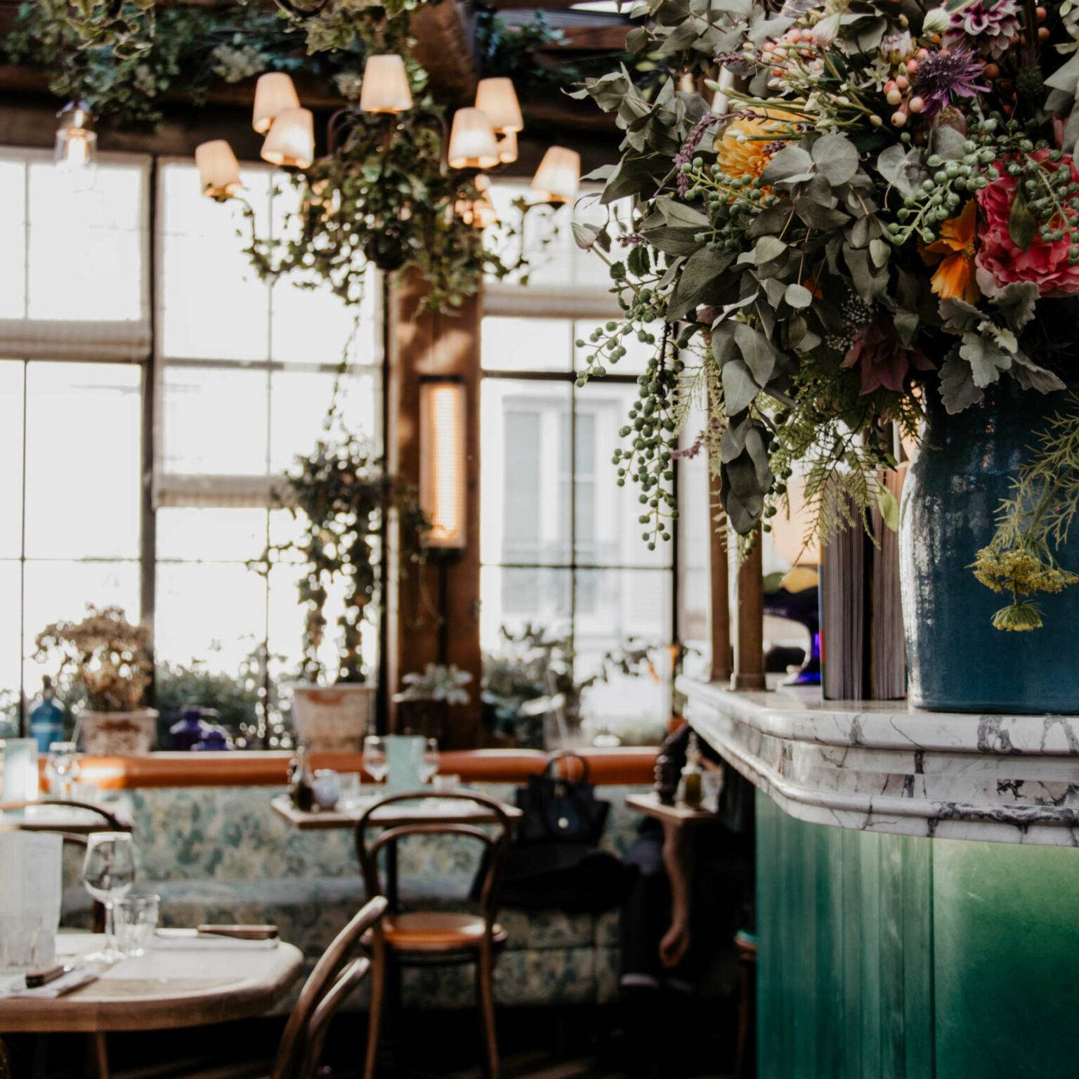 Das Café Pink Mamma im 9. Pariser Arrondissement ist stylish mit Blumen, Pflanzen und Lampen dekoriert.