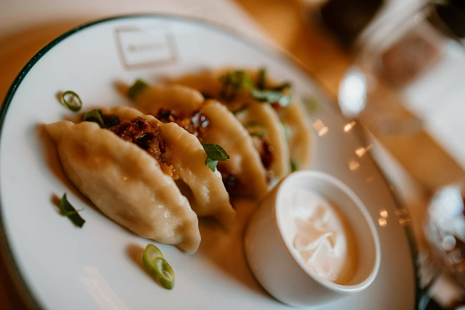 Das polnische Gericht Piroggen schmückt mit Sauerrahm einen Teller in einem Danziger Restaurant.