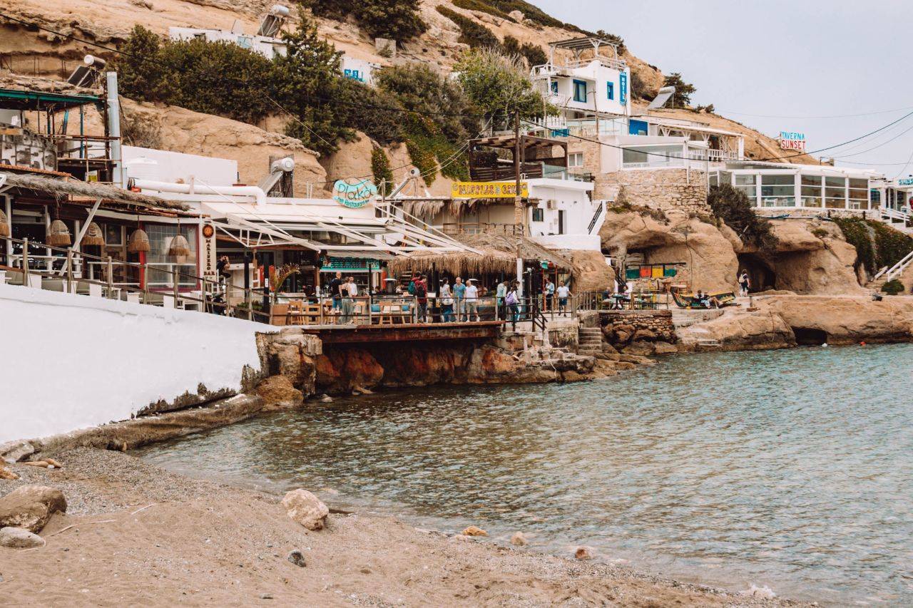 Häuser und Strandbars wurden in die Steinküsten des Dorfs Matala auf Kreta gebaut.