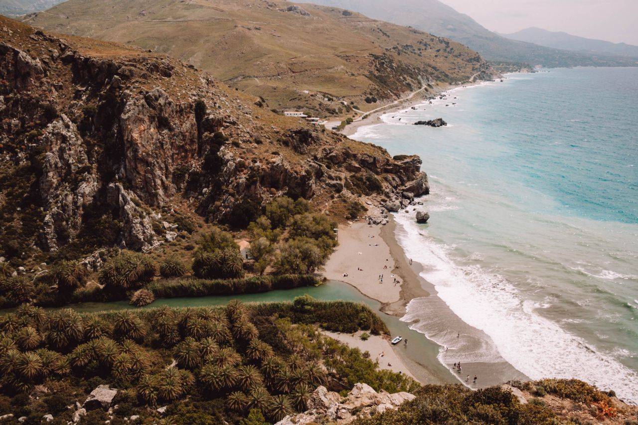 Zwischen begrünter Steinküste und blauem Meer liegt der Preveli Beach auf Kreta.