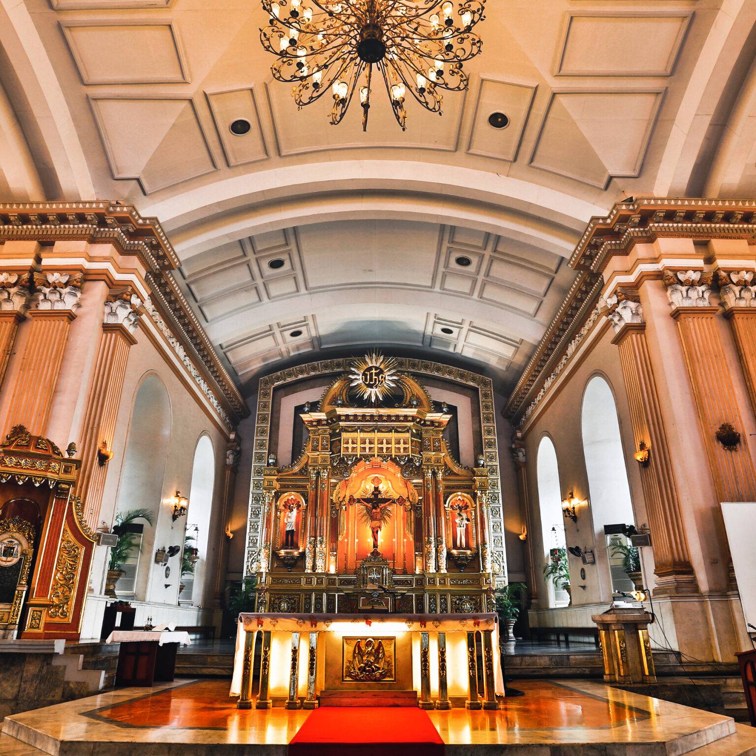 Ein großer Altar steht angestrahlt von warmem Licht in der Basilika.