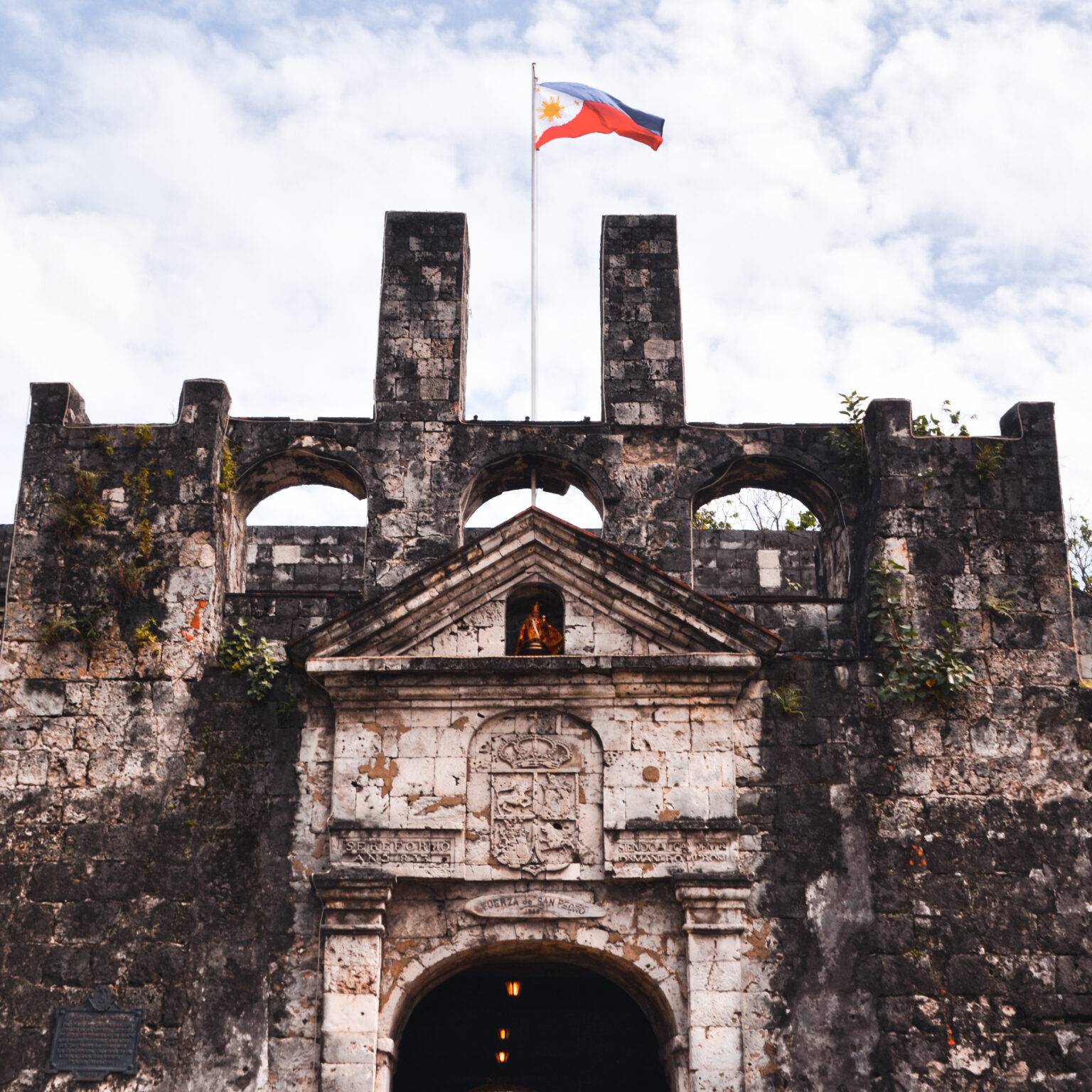 Ein altes und großes steinernes Gebäude mit der Fahne der Philippinen.