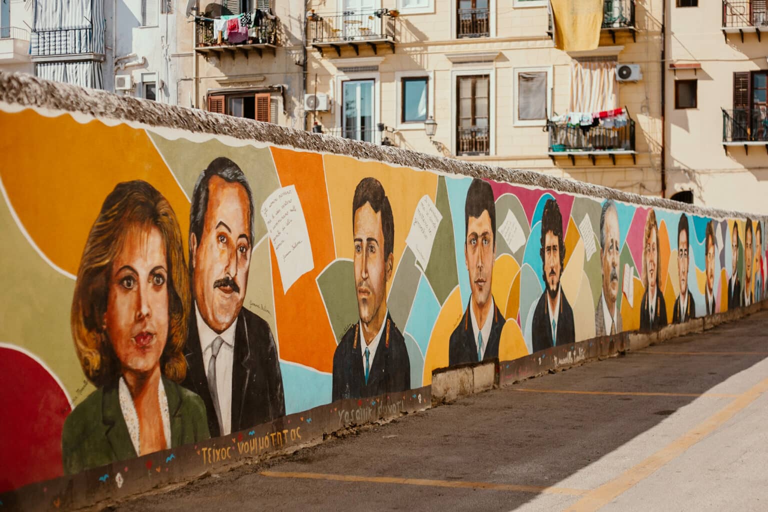 Ein Mural auf einer Wand in Palermo auf dem verschiedene Bilder von Politiker zu sehen sind.