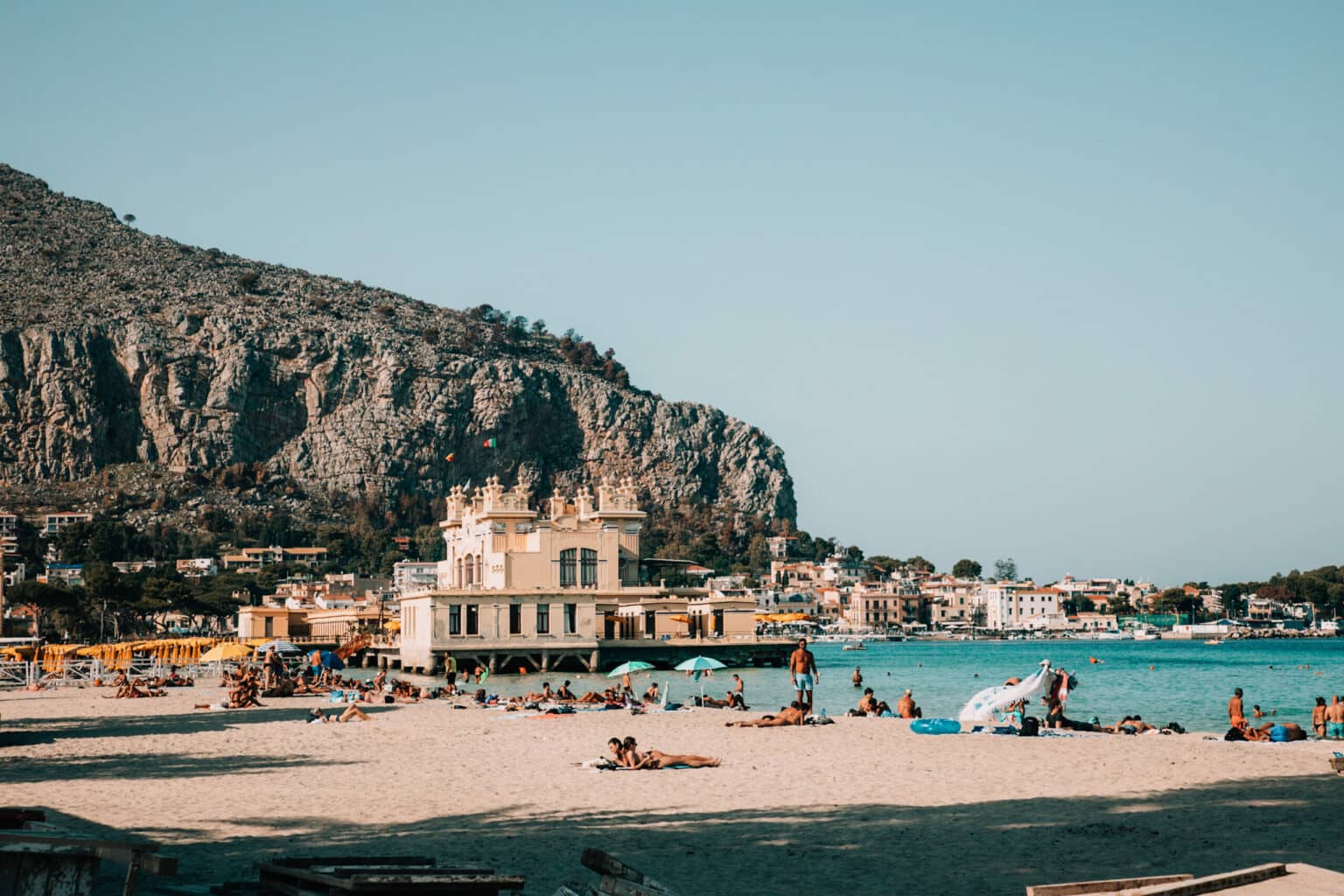 Blick auf den Strand von Mondello mit türkisblauen Wasser im Hintergrund.