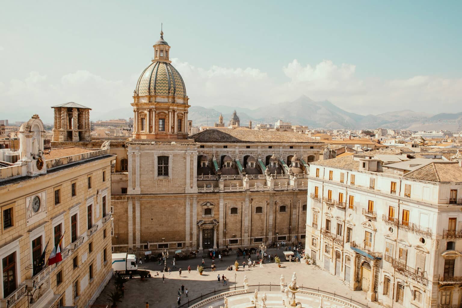 Blick von oben auf einen Platz in der Altstadt Palermos, im Hintergrund die Berge.