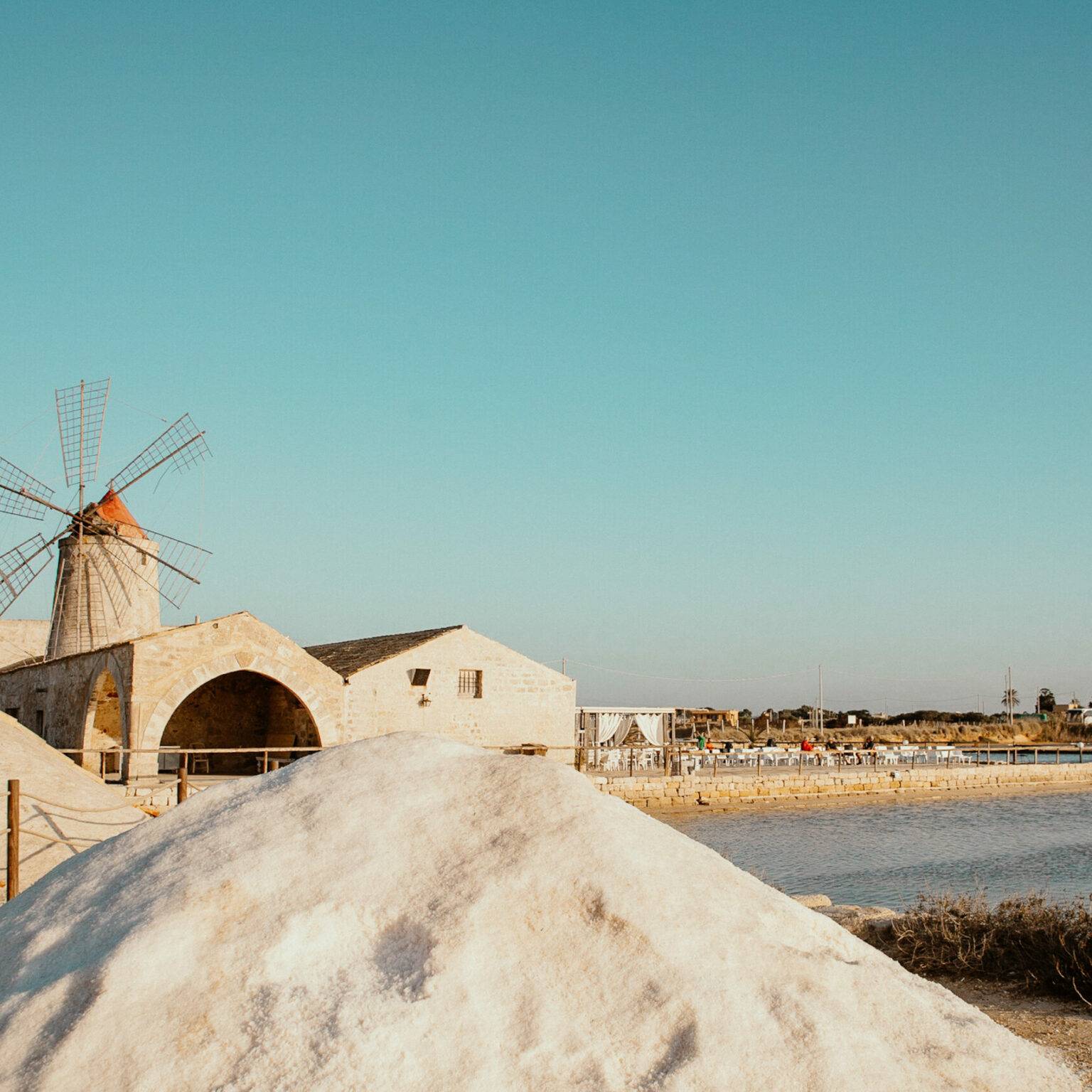 Die Salzgärten von Trapani, in der Mitte steht eine kleine Windmühle.