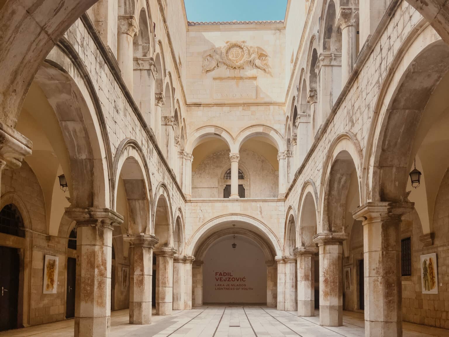 Der Innenhof des Sponza Palasts mit hohen hellen Mauern.