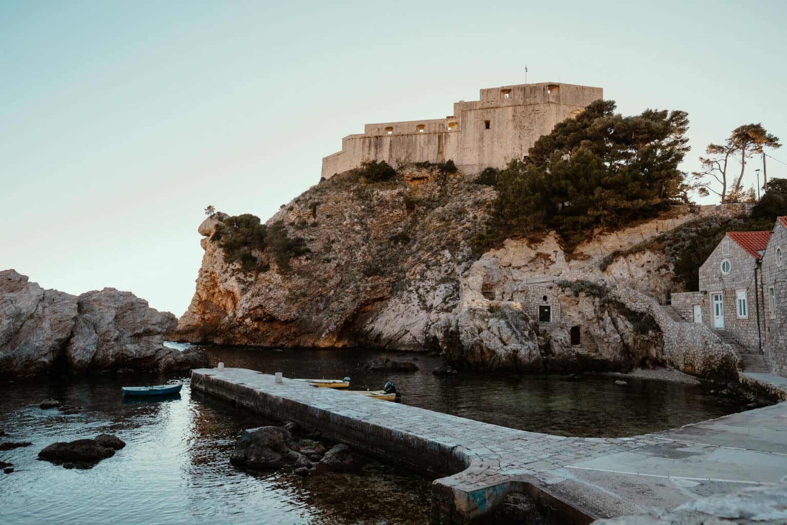 Der Hafen von Dubrovnik umgeben von Felsen und alten Gemäuer.
