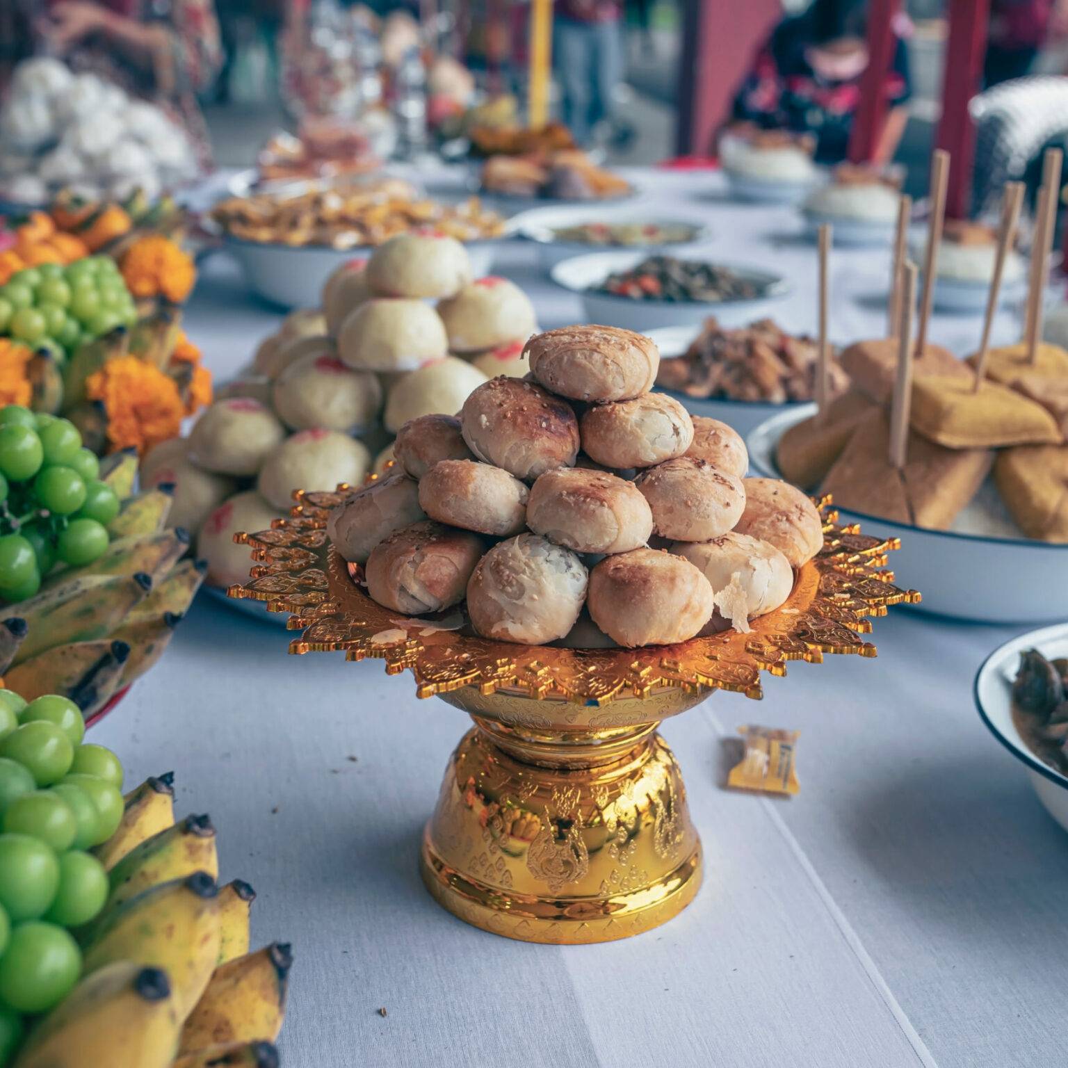 Auf einem Tisch sind zahlreiche Mahlzeiten als Opfergaben aufgestellt.