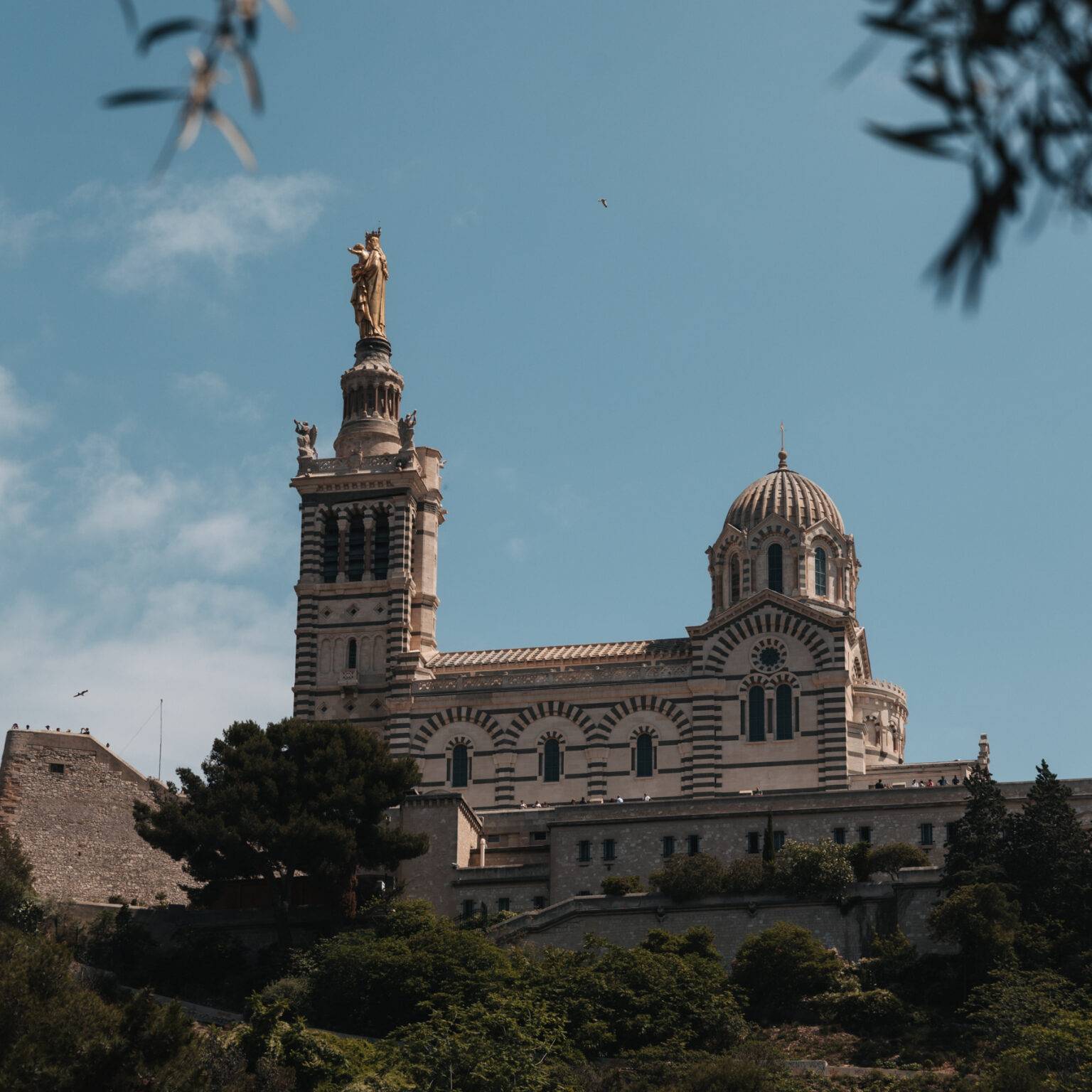 Blick auf die La Notre-Dame de la Garde, mit ihren zwei Türmen und umgeben von einer Mauer.