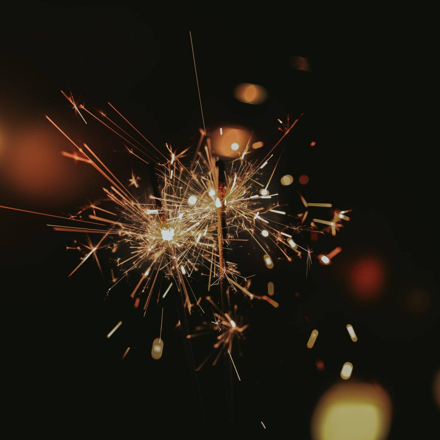 Zwei brennende Wunderkerzen bei Nacht.