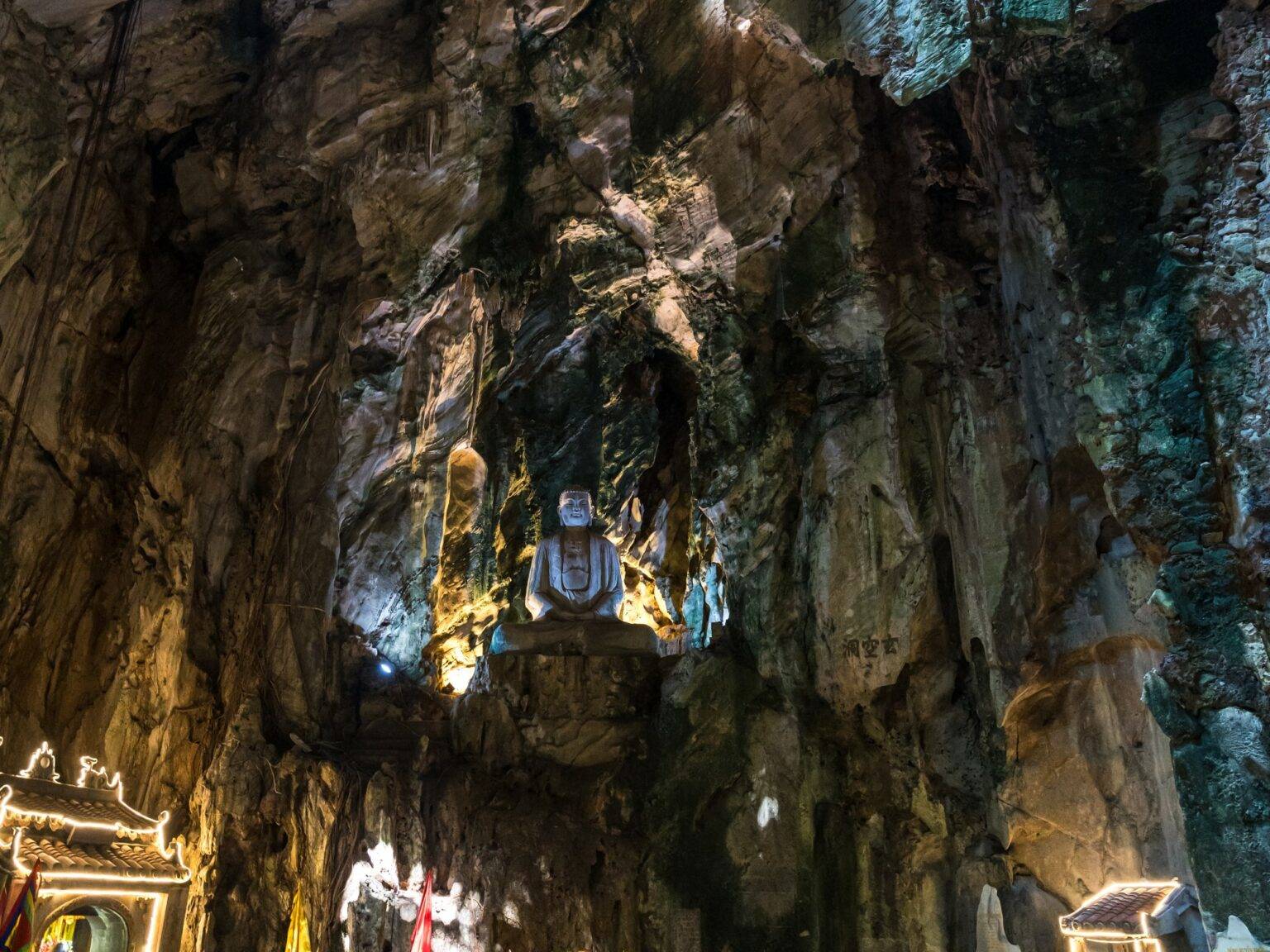 Biggi in einer Höhle mit Buddha-Statue in den Marble Mountains.