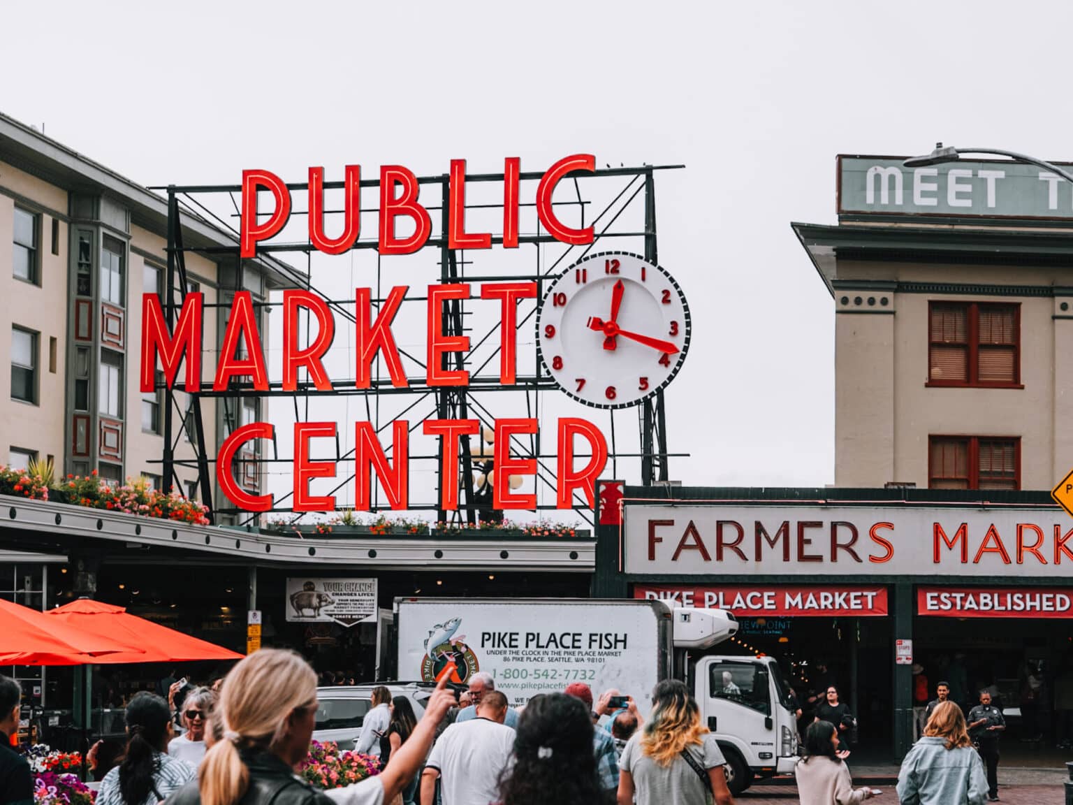 Einige Menschen gehen auf den Haupteingang des Pike Place Market zu.