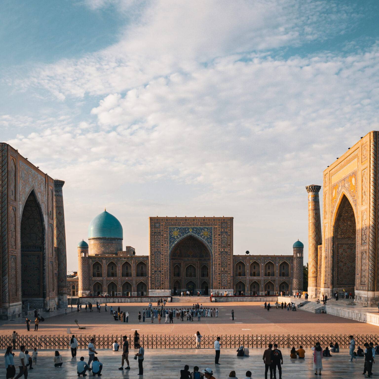 Der Registan-Platz in Samarkand mit einigen Menschen umgeben von drei Madresen.