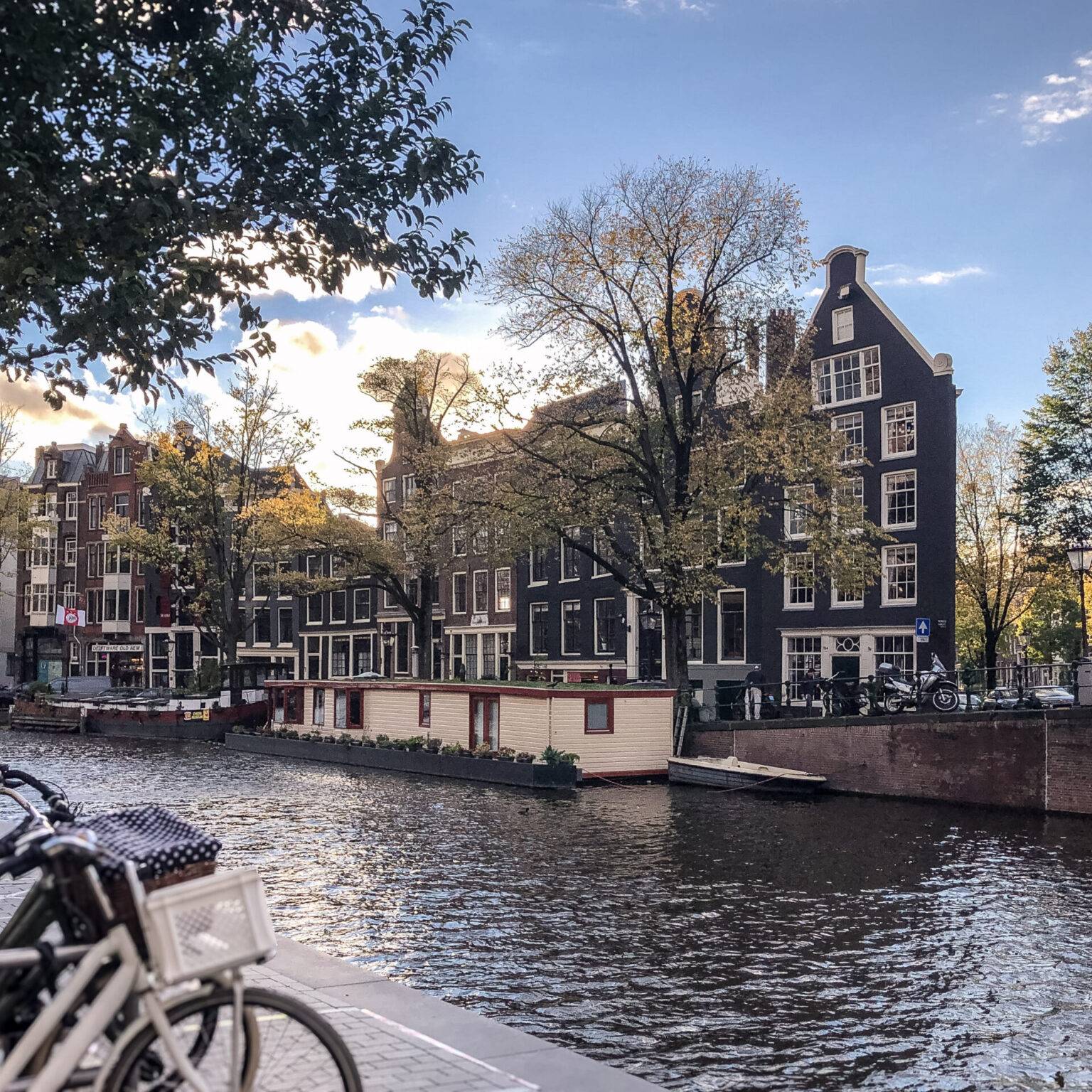 Typische Gracht im Amsterdamer Viertel Jordaan mit Backsteinhäusern, Hausbooten und kleinen Shops.