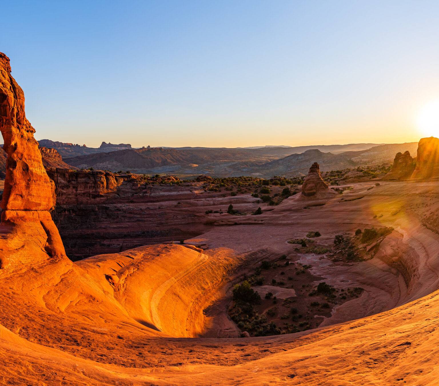 Delicate Arch, die berühmteste Felsformation im Arches National Park in Utah, leuchtet in kräftigen Rottönen im Abendlicht.